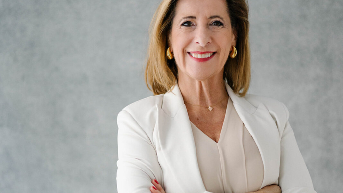 Louisa Böhringer, Executive Branding Expertin, in hellem Business-Outfit vor neutralem Hintergrund, mit ruhiger und souveräner Haltung.