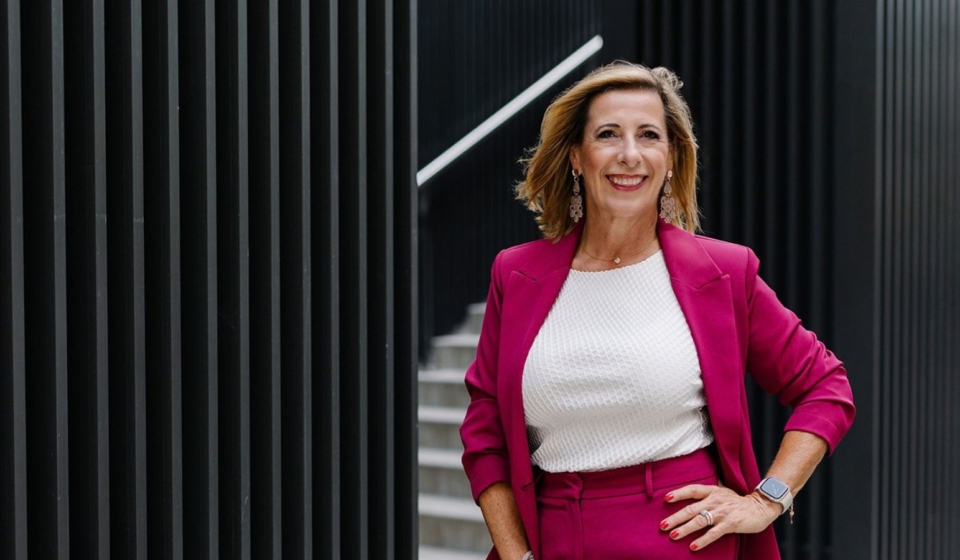 Louisa Böhringer im pinkfarbenen Hosenanzug vor moderner Architektur mit schwarzer Fassade.
